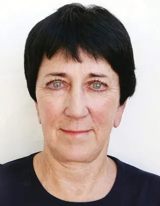 Short-haired woman with light eyes smiling.